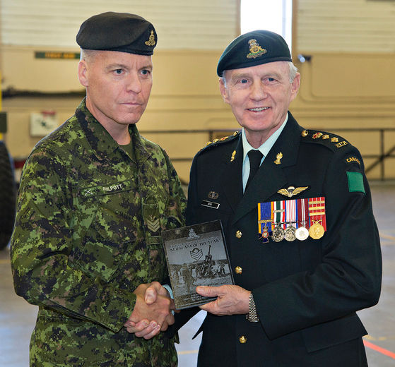 Sgt. Grant Philpott (left) of the 56th Field Regiment Royal Canadian Artillery is presented with the
